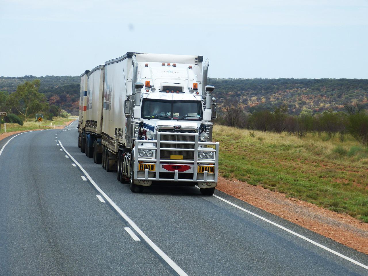 white semi truck driving on road - supply chain issues cause slowdowns and potential food contamination